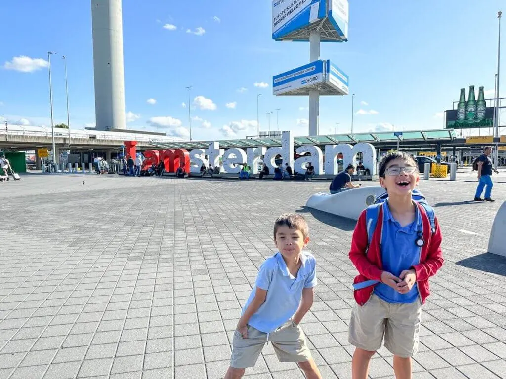 Image of two boys in front of the I Amsterdam sign at the airport