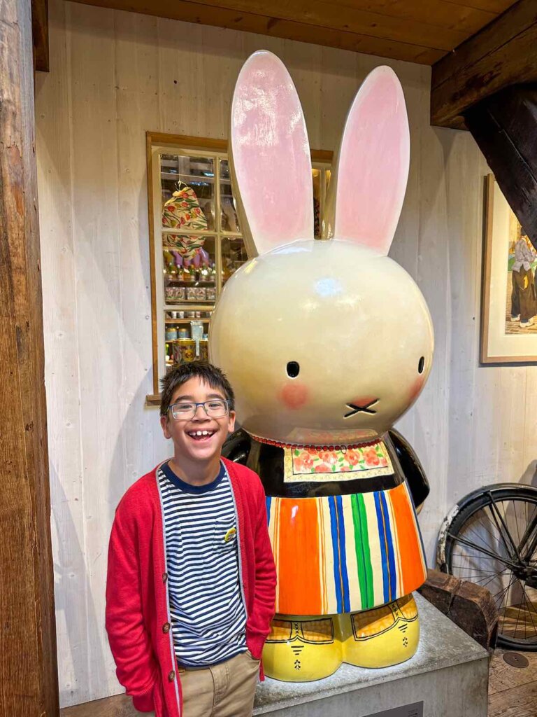 Image of a boy posing with a wooden Miffy statue in Zaanse Schans