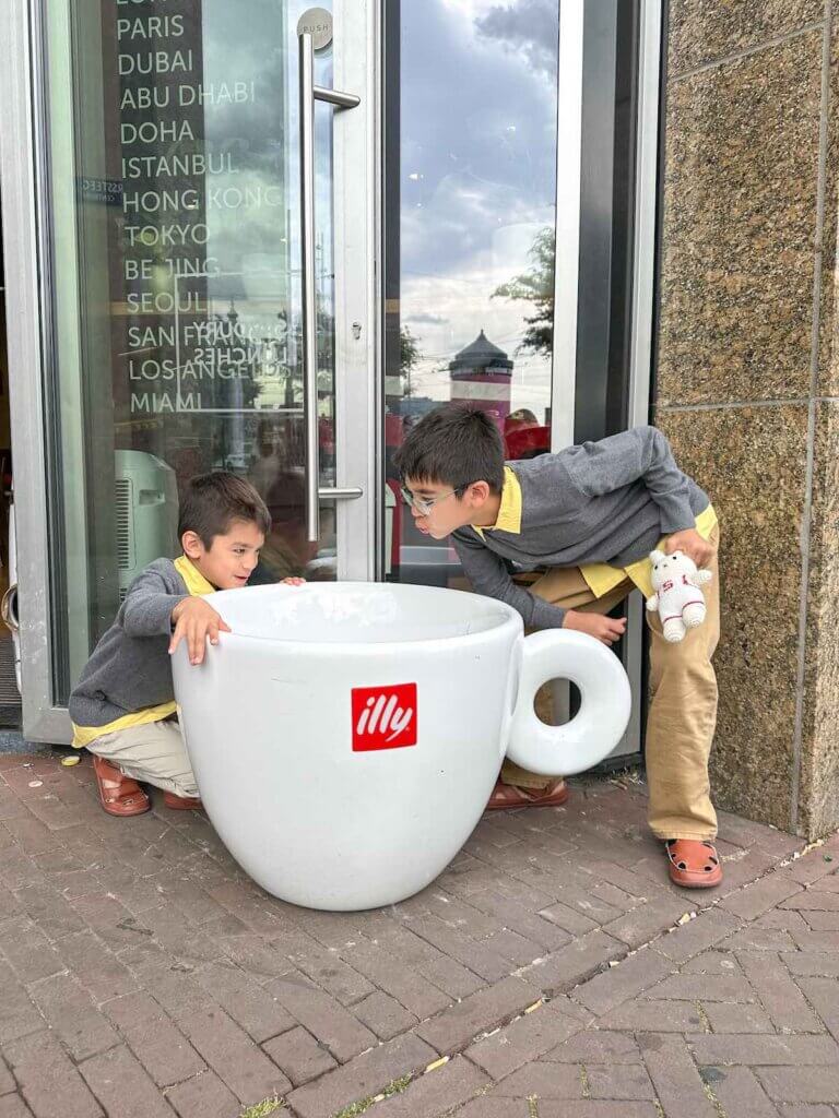 Image of two boys pretending to drink out of an oversized coffee cup in Amsterdam