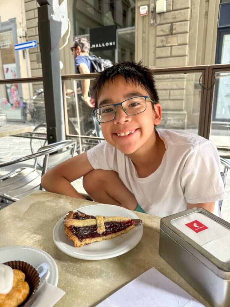 Image of a boy with a slice of pie at Robiglio bakery in Florence Italy