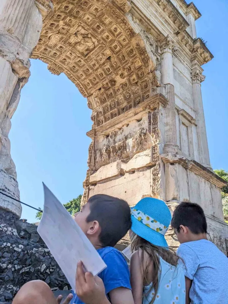 Image of 3 kids looking up at an arch in the Roman Forum
