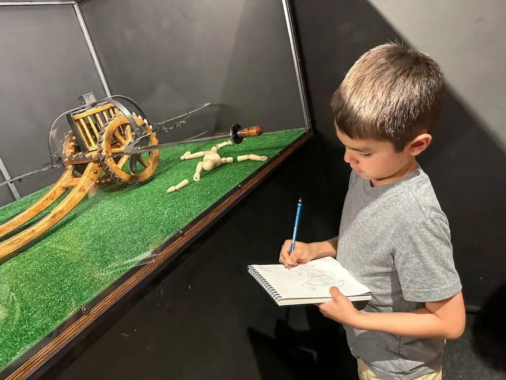 Image of a boy sketching a machine at the Da Vinci museum in Florence Italy