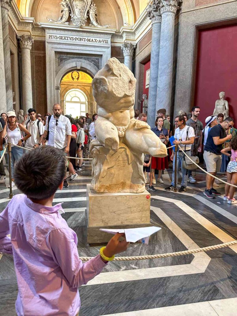 Image of a boy looking at a statue in the Vatican Museum
