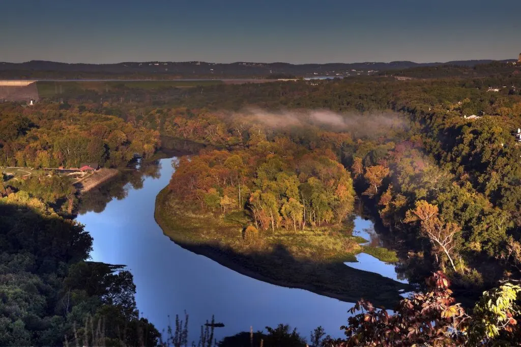 Scenic overlook at sunrise in Branson, Missouri showing the water reservoir from the Table Rock Lake Dam and colorful fall foliage.