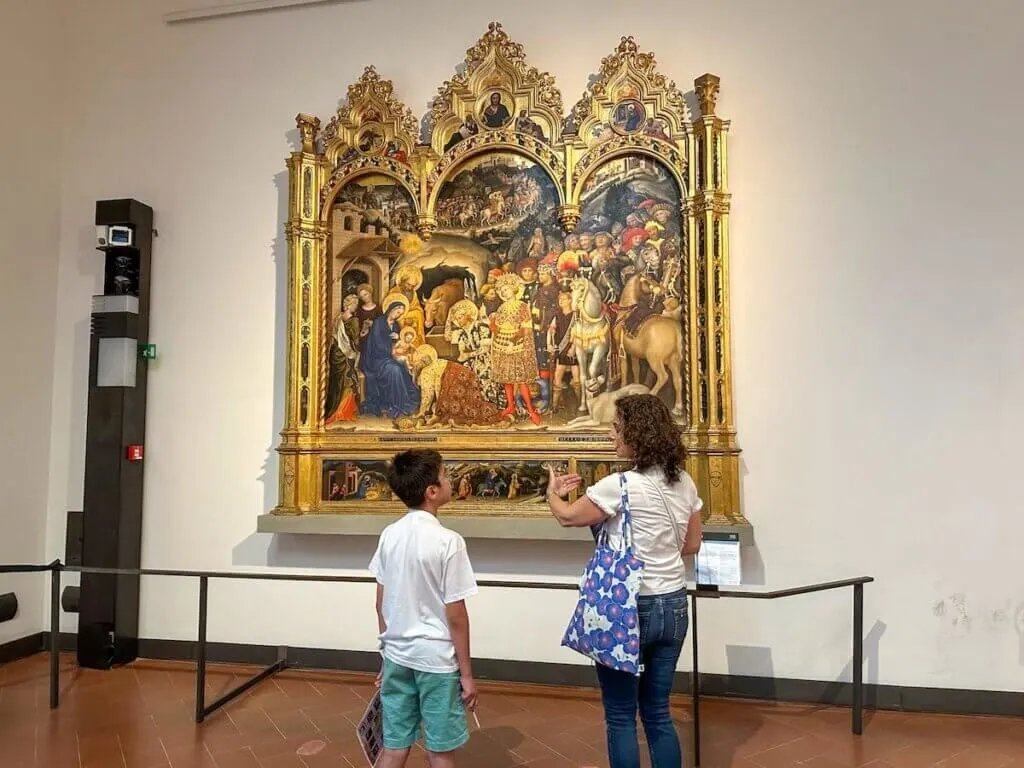 Image of a boy and a teacher looking at a painting in the Uffizi Gallery in Florence Italy