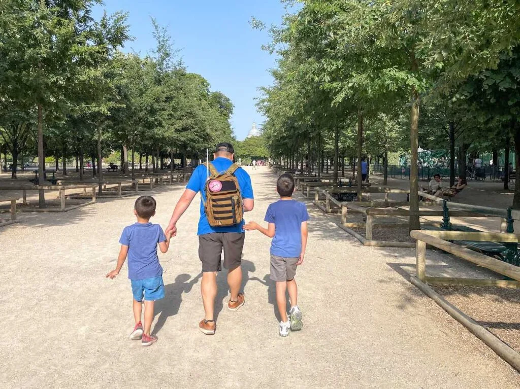 Image of a dad and two boys walking around Jardin du Luxembourg in Paris France