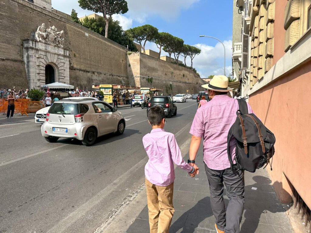 Image of a man and son walking to the Vatican Museums entrance in Italy