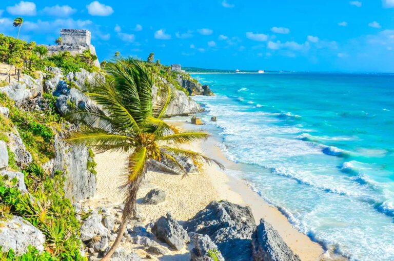Check out this comparison of Cancun vs Tulum by top family travel blog Marcie in Mommyland. Image of Mayan ruins of Tulum at tropical coast. El Castillo Temple at paradise beach. Mayan ruins of Tulum, Quintana Roo, Mexico.