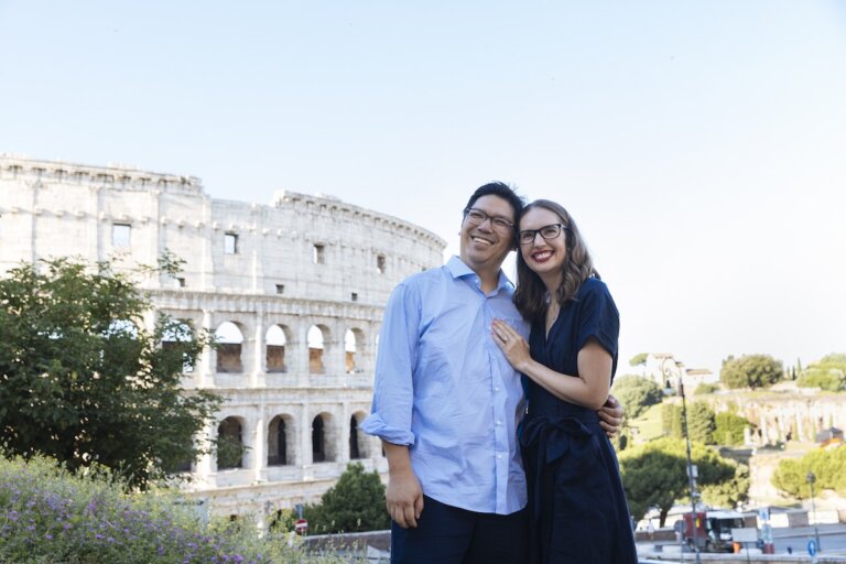 Find out how to plan a trip to Italy with tips by top family travel blog Marcie in Mommyland. Image of a couple in front of the Colosseum in Rome, Italy.