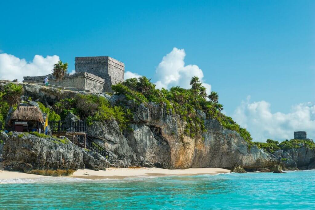 Image of El Castillo, the central piece of the ancient Mayan ruins at Tulum, Mexico, sits atop the cliffside overlooking the Caribbean sea.