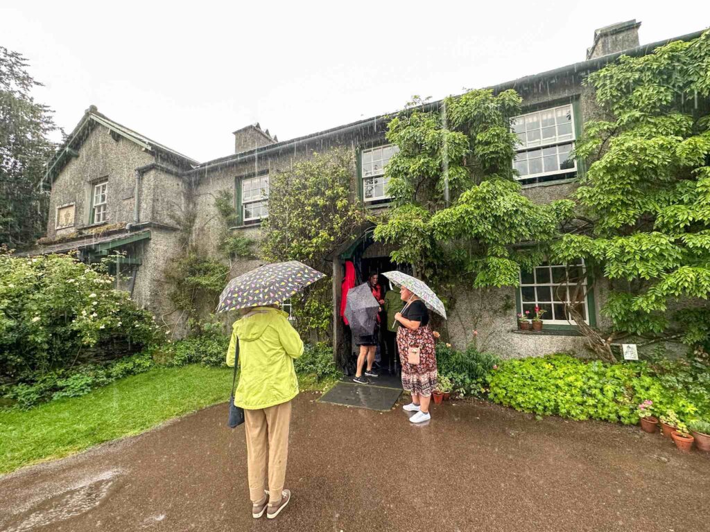 Image of women with umbrellas in front of Hill Top Farm in the Lake District of England