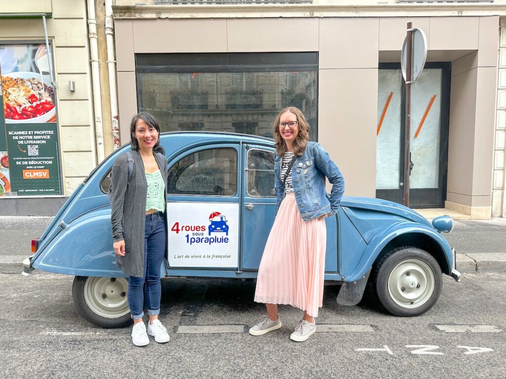 Image of two woman posing in front of a Citroen Car in Paris France
