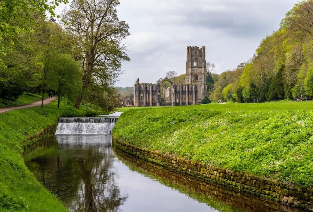 Image of Detail of the ruins of Fountains Abbey in Yorkshire, United Kingdom in the spring with River Skell flowing past