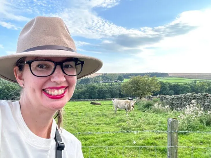 Find out the best free things to do in Yorkshire England recommended by top family travel blog Marcie in Mommyland. Image of a woman in front of a field of sheep.