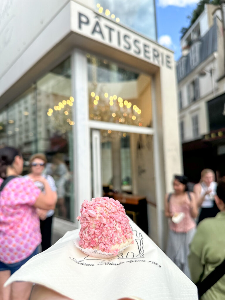 Image of a little pink pastry in front of a patisserie in Montmartre in Paris