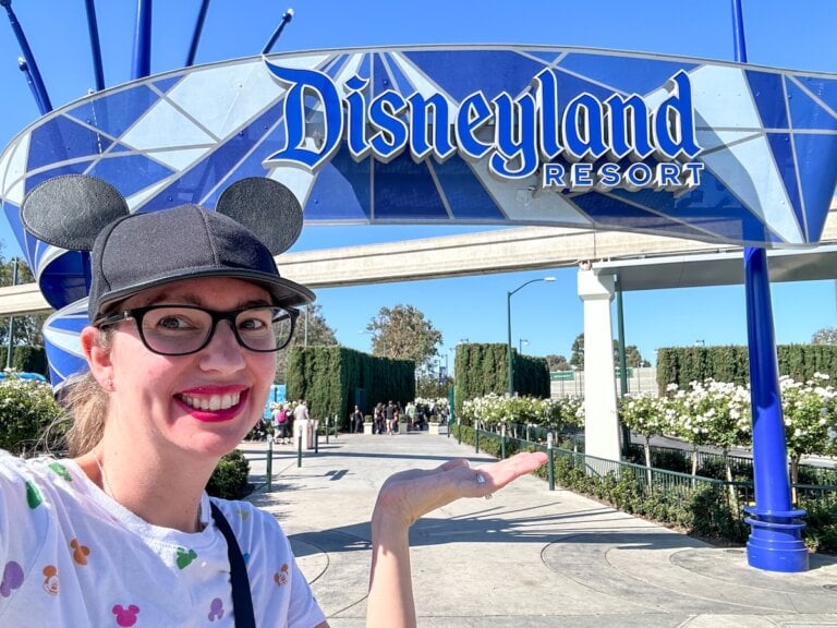Check out this list of the best Disneyland hotels within walking distance of the parks recommended by top family travel blog Marcie in Mommyland. Image of Marcie Cheung, owner of Marcie in Mommyland in front of the Disneyland entrance