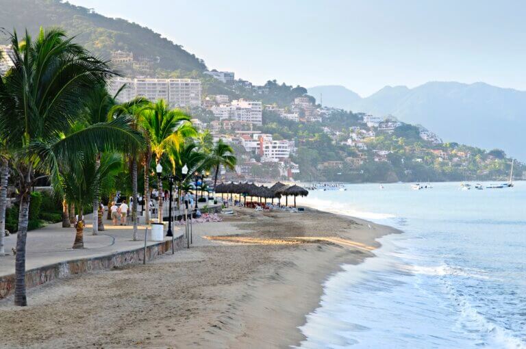 Find out the best Puerto Vallarta travel tips recommended by top family travel blog Marcie in Mommyland. Image of Beach and Malecon on Pacific Ocean in Puerto Vallarta, Mexico