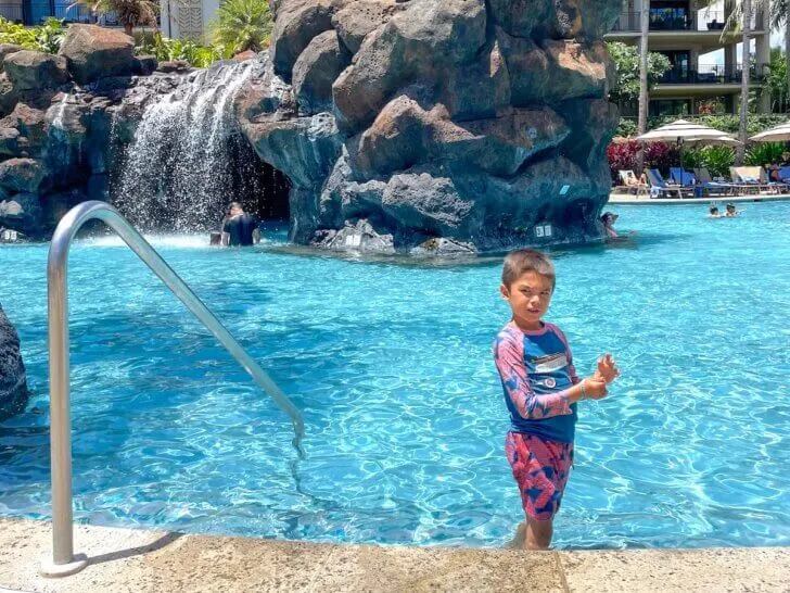 Check out this list of the best Kauai family resorts recommended by top family travel blog Marcie in Mommyland. Image of a boy at the Koloa Landing Resort pool. Photo credit: Marcie Cheung of Marcie in Mommyland