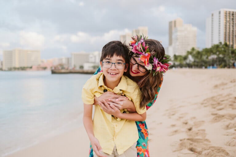 Check out these Oahu travel tips by top family travel blog Marcie in Mommyland. Image of Marcie Cheung and her son in Waikiki.