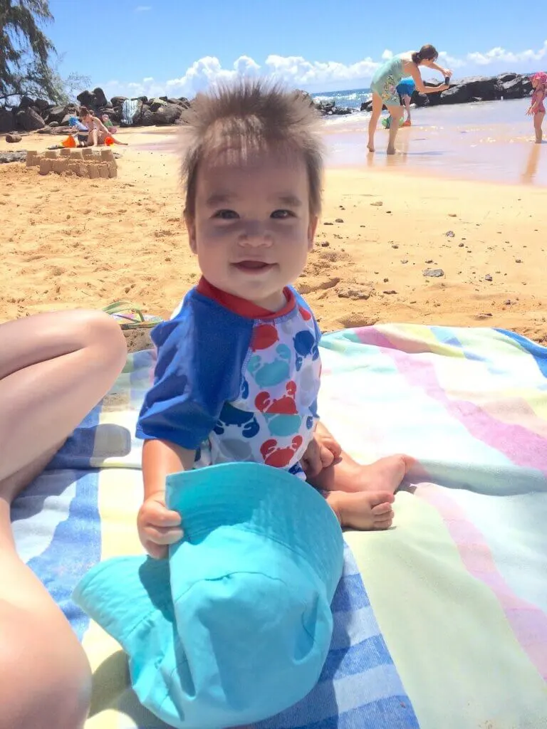 Image of a baby on a beach towel on a beach in Hawaii. Photo credit: Marcie Cheung of Marcie in Mommyland