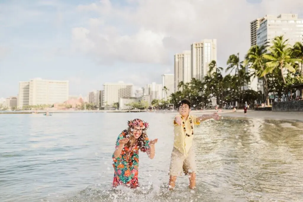 Image of Marcie Cheung of Marcie in Mommyland and her son in the ocean at Waikiki Beach.