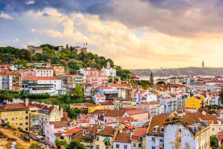 Check out the best Lisbon hotels for families recommended by top family travel blog Marcie in Mommyland. Image of Lisbon, Portugal skyline at Sao Jorge Castle at dusk.