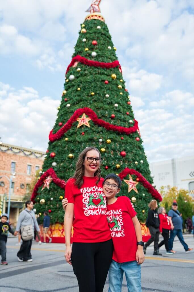 Image of Marcie Cheung and her son in front of a Christmas tree at Universal Studios Florida. Photo credit: Sees the Day Photography
