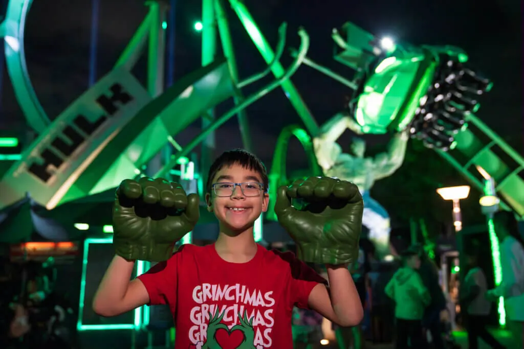 Image of a boy wearing Hulk hands in front of the Hulk rollercoaster at Universal Studios Florida. Photo credit: Sees the Day Photography