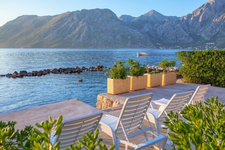 Check out this list of the best all-inclusive trips to New Zealand by top travel blog Marcie in Mommyland. Image of deck chairs on the coast of New Zealand