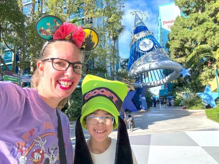 Check out this comparison of the 3 Disneyland Resort hotels by top family travel blogger Marcie in Mommyland. Image of Marcie Cheung and her son in front of the Disneyland Hotel sign