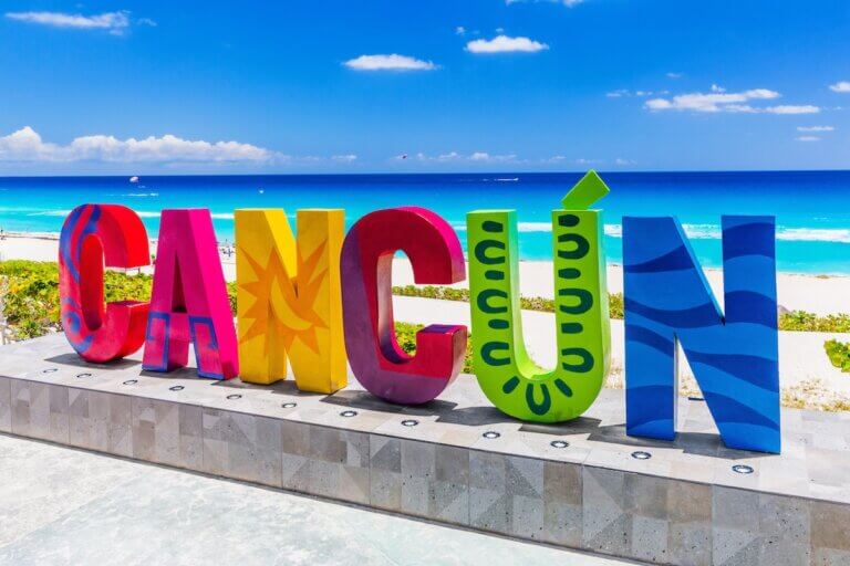 Check out the best things to do in Cancun with kids recommended by top family travel blog Marcie in Mommyland. Image of the Cancun Sign at Dolphin Beach.
