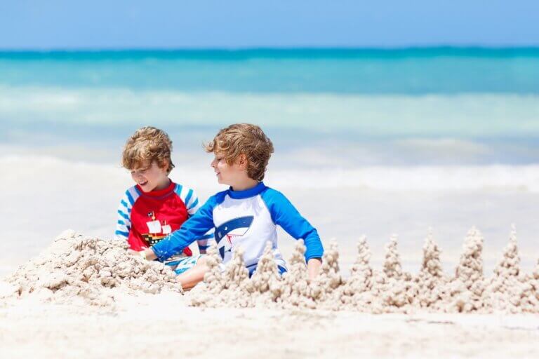 Check out the best things to do in Playa del Carmen with kids recommended by top family travel blog Marcie in Mommyland. Image of Two little kids boys having fun with building a sand castle on tropical beach of Playa del Carmen, Mexico. children playing together on their vacations Twins, Happy brothers laughing and smiling