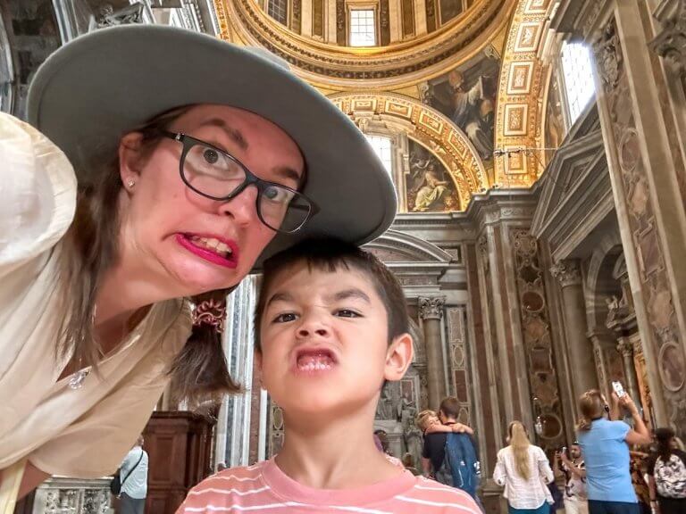 Find out why summer is the worst time to visit Europe with tips and personal experiences from top family travel blog Marcie in Mommyland. Image of Marcie Cheung and her son inside the Vatican in Italy.