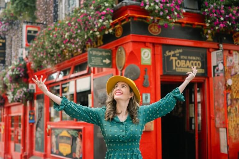 Find out the top Dublin travel tips for people visiting Ireland for the first time recommended by top travel blog Marcie in Mommyland. Image of Marcie Cheung in front of the famous Temple Bar in Dublin