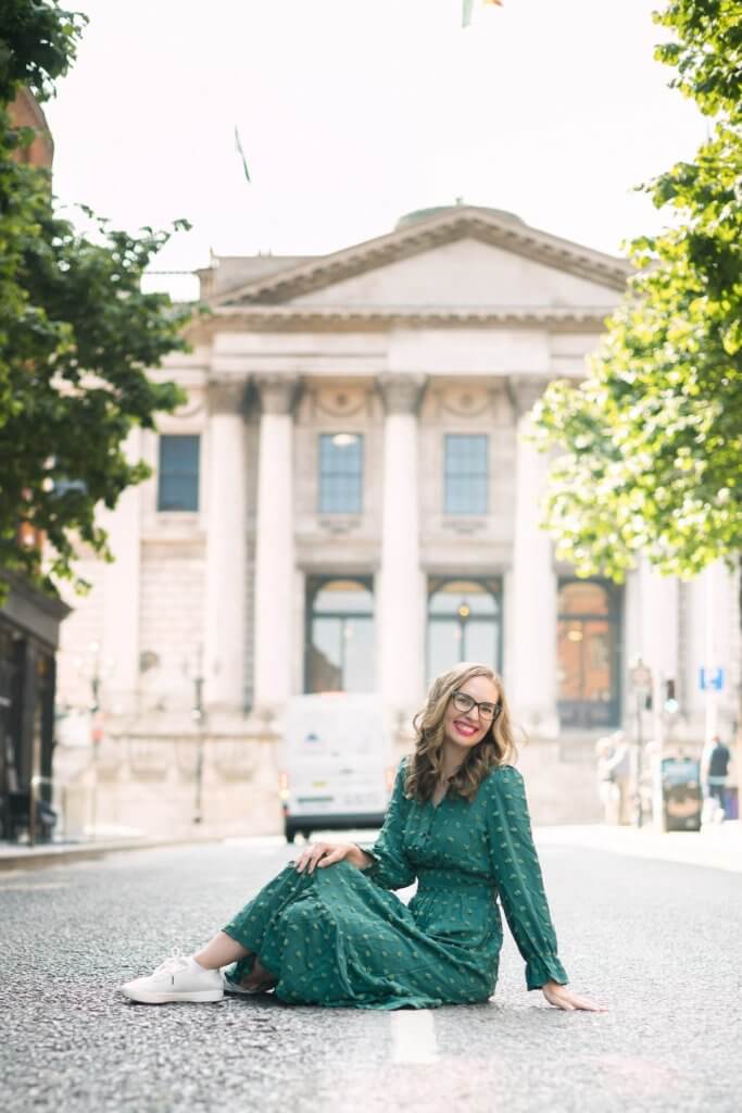 Image of Marcie Cheung sitting in the street in front of City Hall in Dublin Ireland