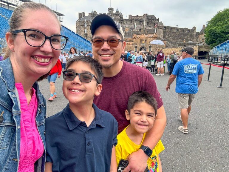 Find out whether to visit Edinburgh vs Dublin for your next family trip. Image of Marcie Cheung and her family in front of Edinburgh Castle.