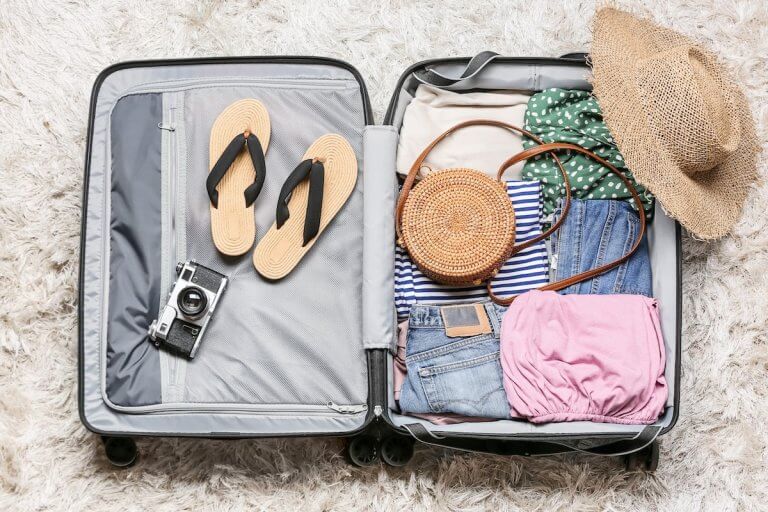 Find out what to pack for Europe this summer with tips from top family travel blog Marcie in Mommyland. Image of a suitcase with cute women's clothing items in it.