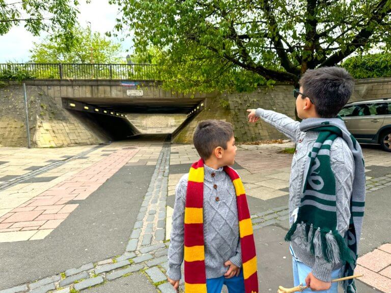 Find out the coolest Harry Potter places in Scotland according to top family travel blog Marcie in Mommyland. Image of two boys wearing Hogwarts Scarves in Edinburgh