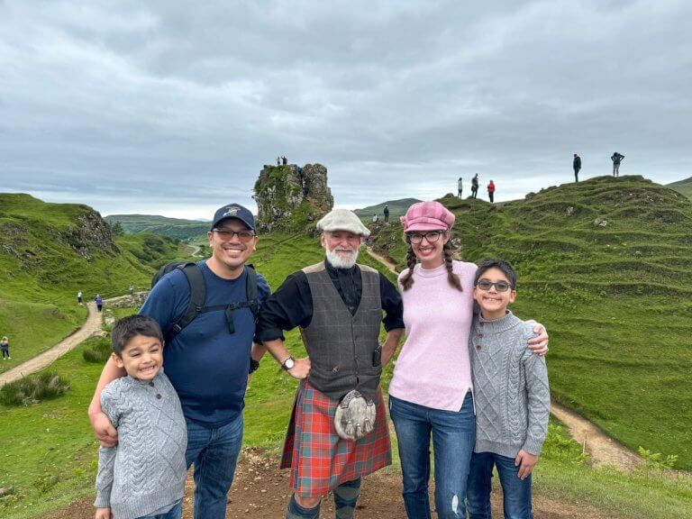 Find out the best Scotland tours for families according to top family travel blog Marcie in Mommyland. Image of Marcie Cheung and her family with a tour guide