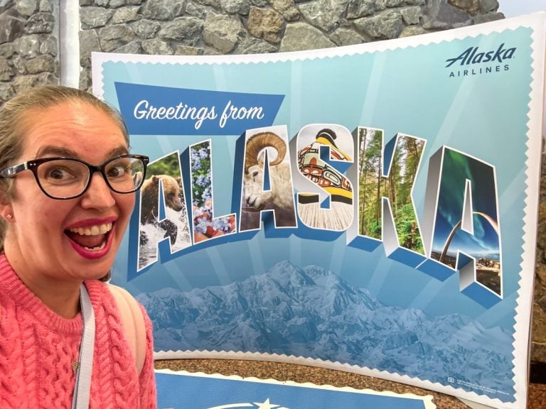 Find out what surprised me about my first trip to Alaska. Image of Marcie Cheung in front of a Welcome to Alaska sign