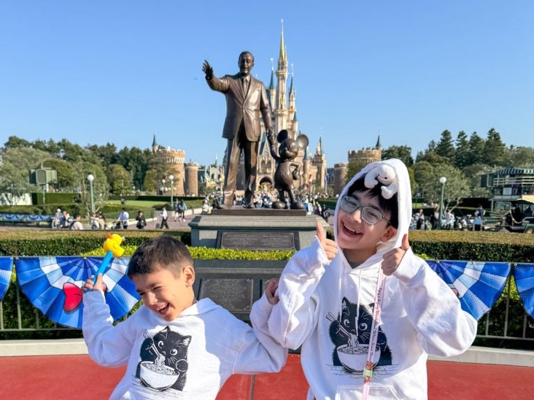 Check out our review of Tokyo Disneyland vs DisneySea. Image of two boys at Tokyo Disneyland