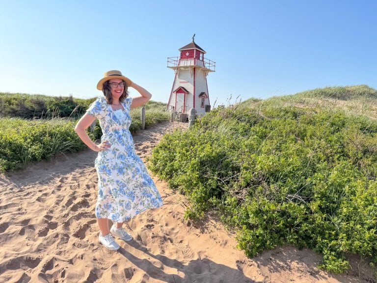 Image of Marcie Cheung in front of a lighthouse on Prince Edward Island in Canada