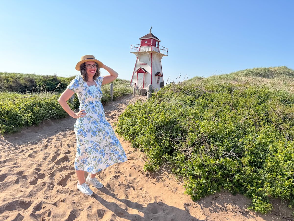 Image of Marcie Cheung in front of a lighthouse on Prince Edward Island in Canada